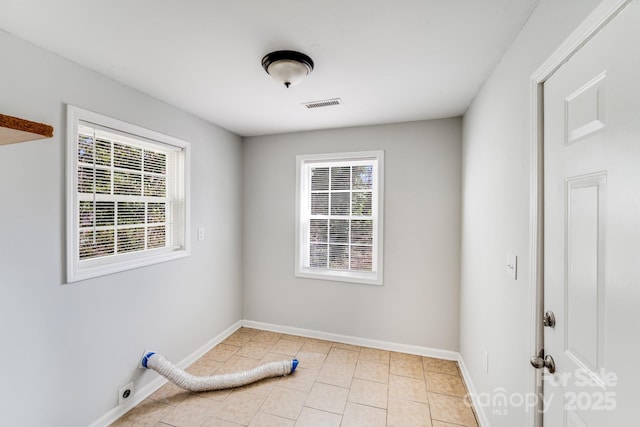 spare room with light tile patterned floors, visible vents, and baseboards