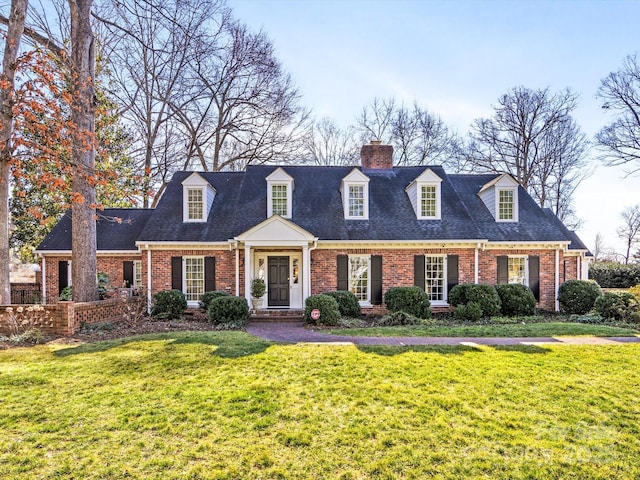 cape cod house featuring a front yard