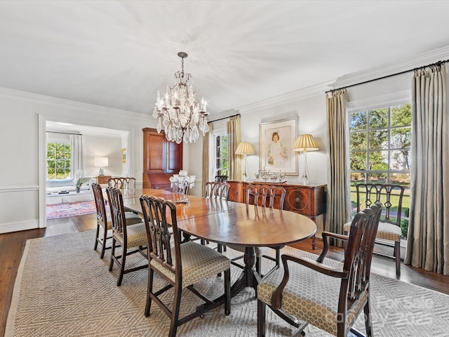 dining area featuring crown molding, a notable chandelier, and light wood-type flooring