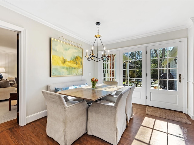 dining room with crown molding, dark wood-type flooring, and a chandelier