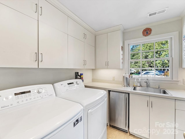 laundry room featuring cabinets, washing machine and dryer, sink, and ornamental molding