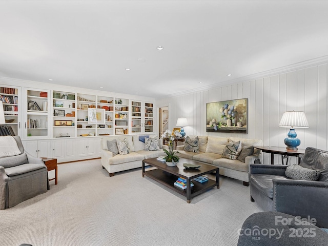 carpeted living room with ornamental molding and built in features