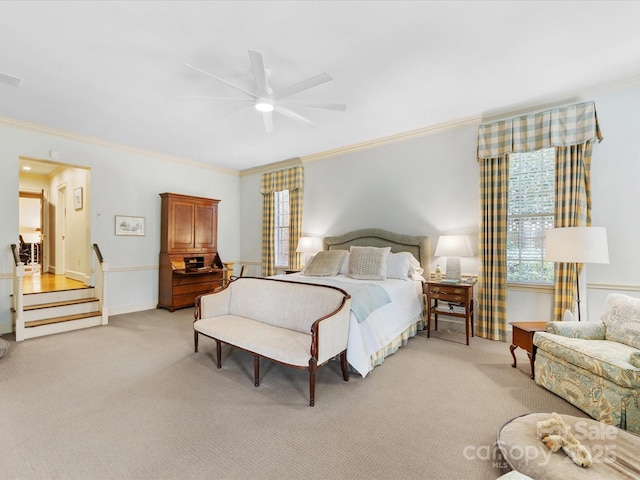 bedroom featuring ornamental molding, light colored carpet, and ceiling fan