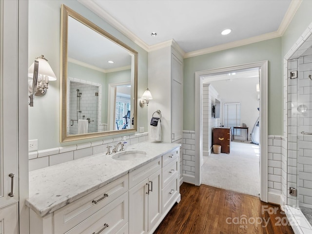 bathroom with vanity, hardwood / wood-style flooring, ornamental molding, and tile walls