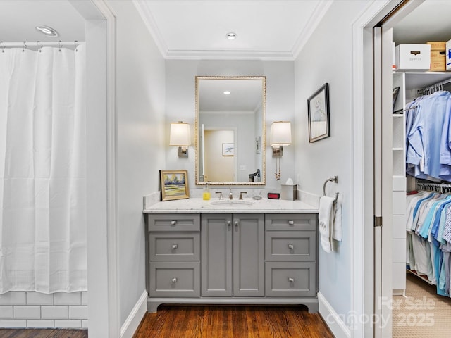 bathroom with crown molding, vanity, and hardwood / wood-style flooring