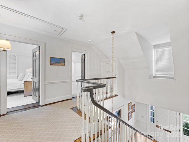 hallway with vaulted ceiling, wood-type flooring, and a chandelier