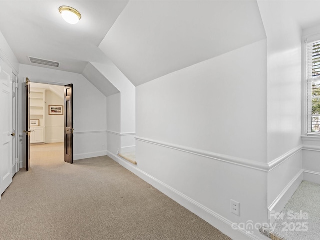 additional living space with plenty of natural light, light colored carpet, and vaulted ceiling