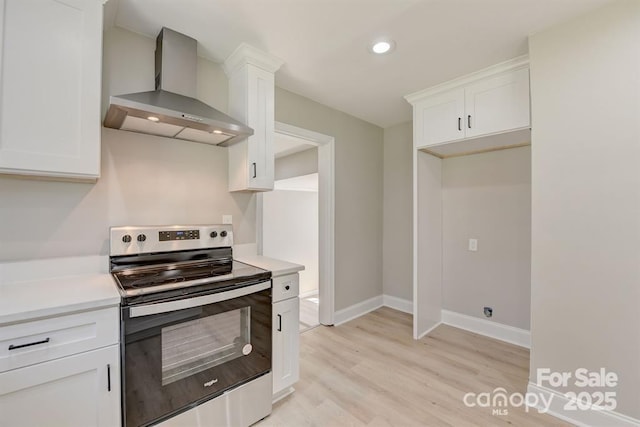 kitchen featuring white cabinetry, electric range, and wall chimney exhaust hood