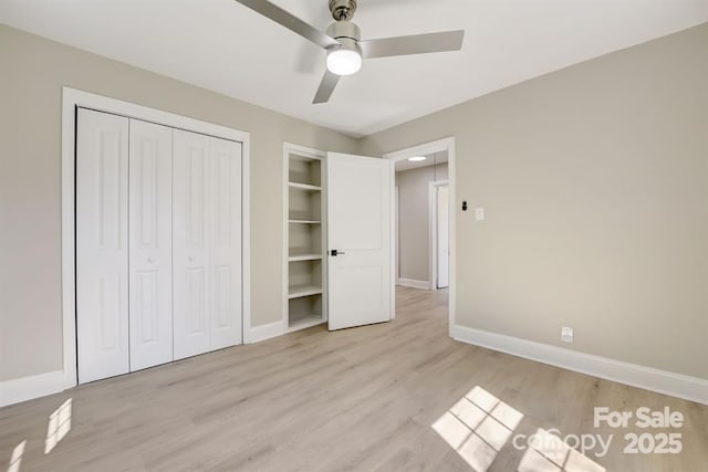 unfurnished bedroom with light hardwood / wood-style flooring, a closet, and ceiling fan