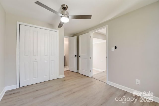 unfurnished bedroom featuring light hardwood / wood-style flooring, ceiling fan, and a closet