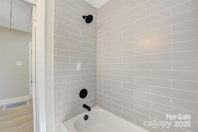 bathroom with tiled shower / bath combo and wood-type flooring