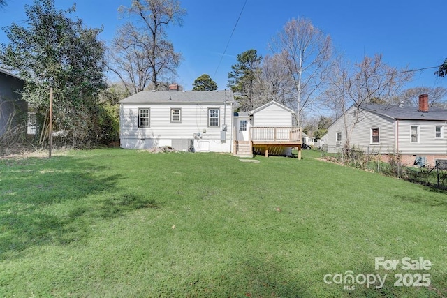 rear view of property with a yard and a deck