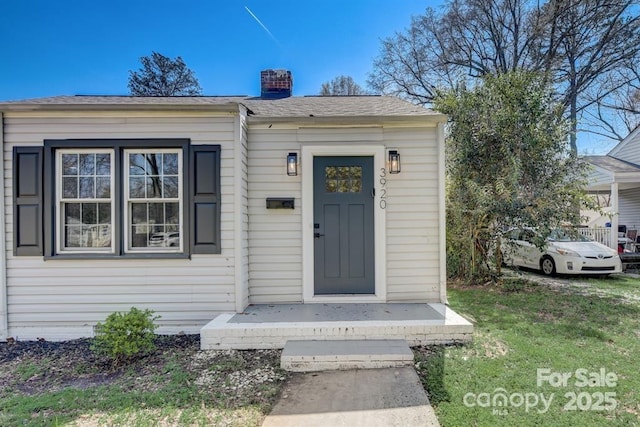 entrance to property with a lawn