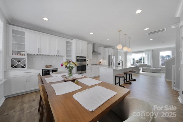 dining area featuring sink, crown molding, and light hardwood / wood-style floors