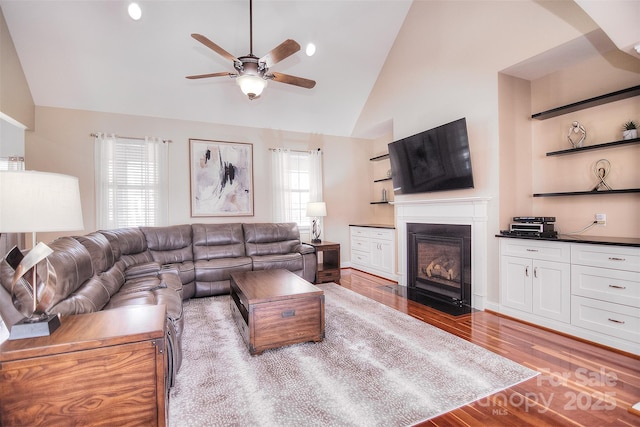 living room featuring hardwood / wood-style floors, high vaulted ceiling, a wealth of natural light, and ceiling fan