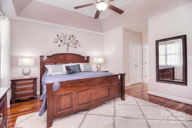 bedroom featuring a tray ceiling, hardwood / wood-style flooring, and ceiling fan