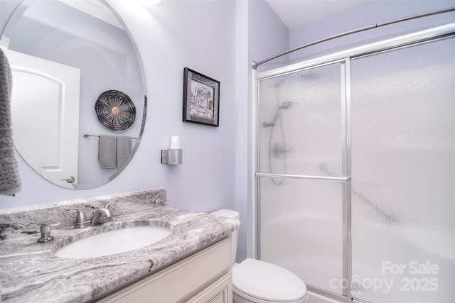 bathroom featuring vanity, toilet, and an enclosed shower