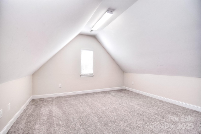 additional living space featuring lofted ceiling and carpet