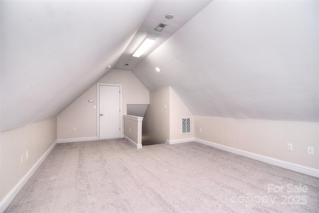 additional living space featuring lofted ceiling and light carpet