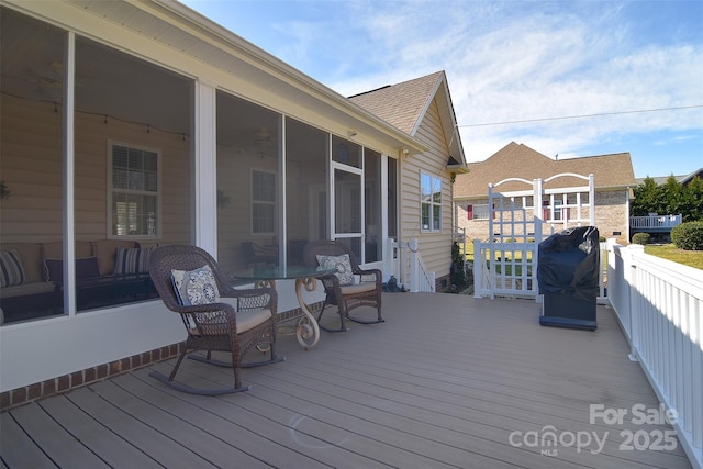 wooden terrace with a sunroom and a grill