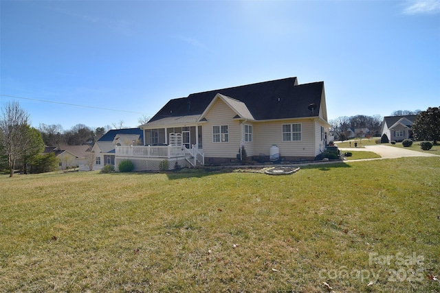 back of property with a yard and covered porch