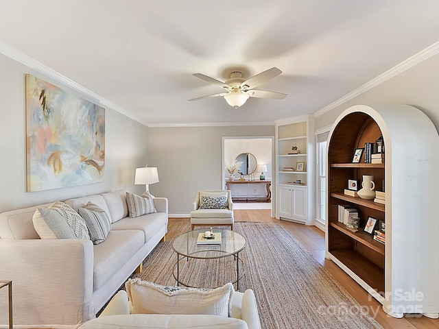 living room with hardwood / wood-style flooring, ceiling fan, and ornamental molding