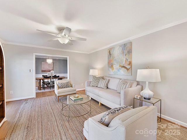 living room with hardwood / wood-style flooring, ornamental molding, and ceiling fan