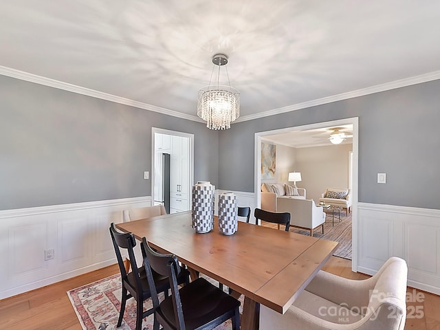 dining space featuring crown molding, a notable chandelier, and light hardwood / wood-style floors