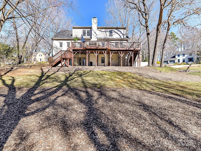 rear view of property with a wooden deck and a lawn