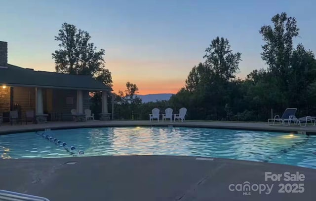 pool at dusk with a patio