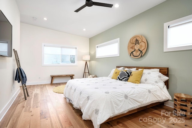 bedroom featuring ceiling fan, lofted ceiling, light hardwood / wood-style floors, and multiple windows