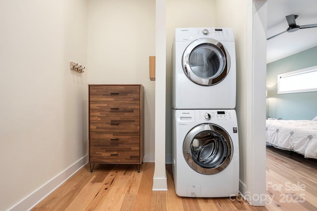 washroom featuring light hardwood / wood-style floors, ceiling fan, and stacked washing maching and dryer