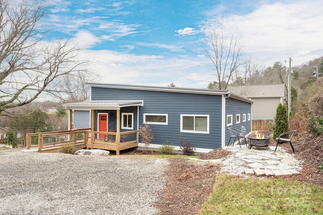view of front of house with a wooden deck and an outdoor fire pit