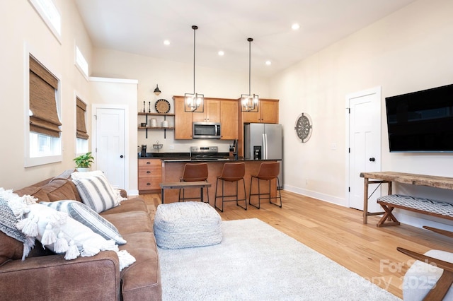 living room with light hardwood / wood-style floors and a high ceiling