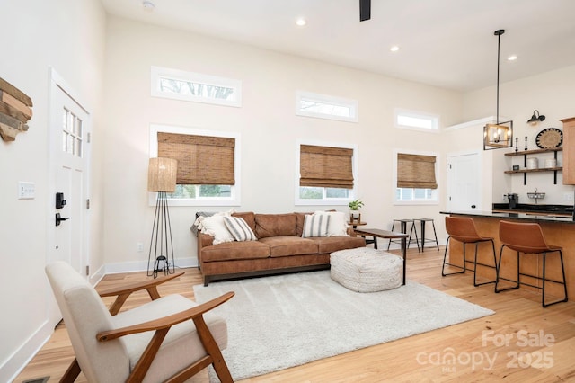 living room featuring a high ceiling and light wood-type flooring