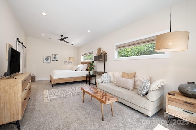 bedroom featuring lofted ceiling, a barn door, and carpet