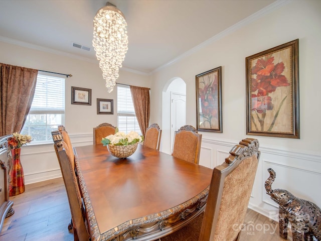 dining area featuring a healthy amount of sunlight, a chandelier, and light wood-type flooring