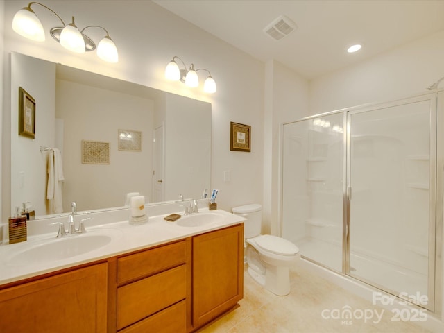 bathroom with tile patterned floors, vanity, toilet, and a shower with shower door