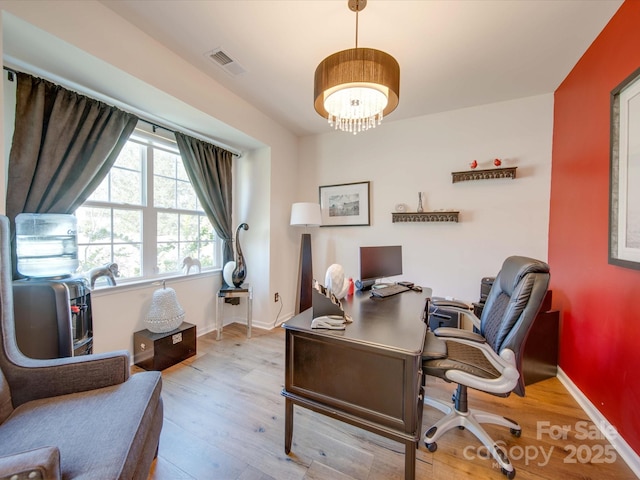 office space with an inviting chandelier and light hardwood / wood-style flooring