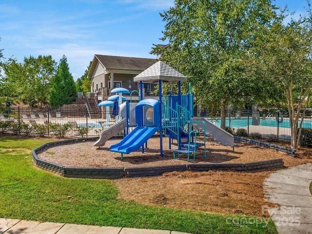 view of playground featuring a fenced in pool