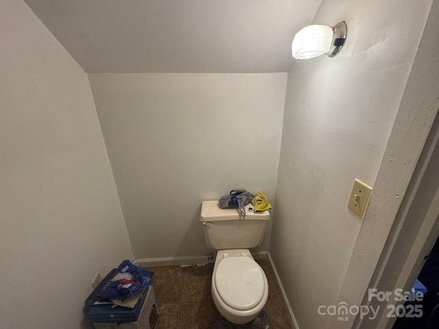 bathroom with lofted ceiling and toilet