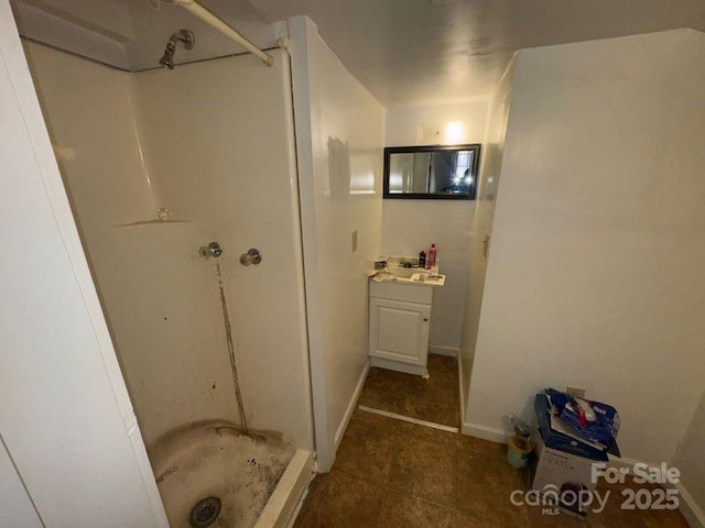 bathroom with tile patterned flooring, a shower, and vanity