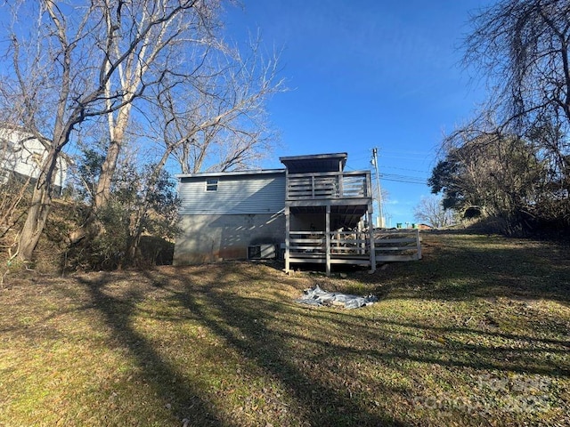 back of house featuring a wooden deck and a yard