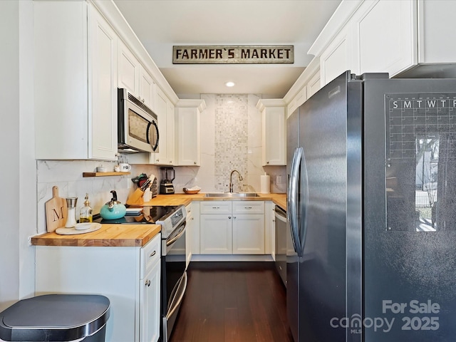 kitchen with sink, white cabinetry, wooden counters, appliances with stainless steel finishes, and dark hardwood / wood-style flooring