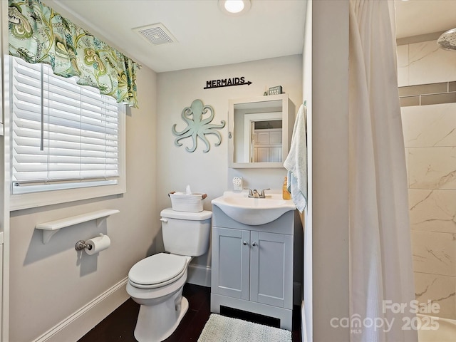 bathroom with hardwood / wood-style floors, vanity, a shower with shower curtain, and toilet