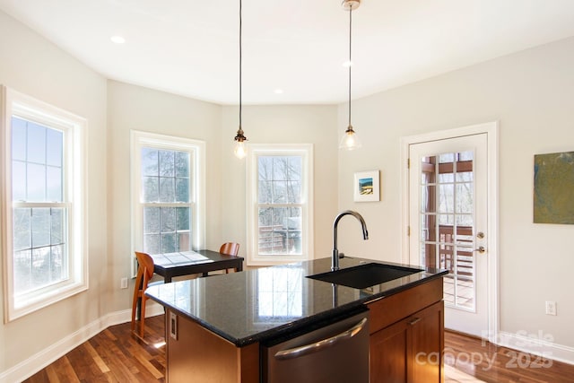 kitchen featuring sink, decorative light fixtures, a center island with sink, stainless steel dishwasher, and dark hardwood / wood-style flooring