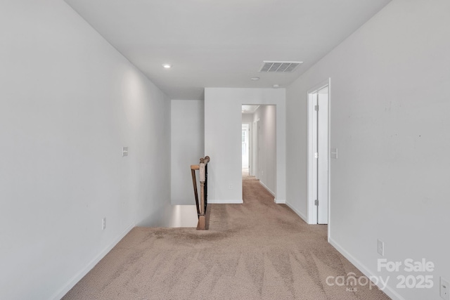 corridor featuring light colored carpet