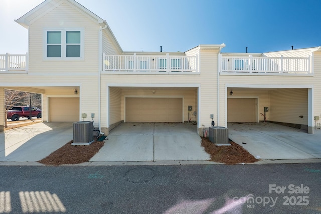 view of front facade with central AC unit, a garage, and a balcony