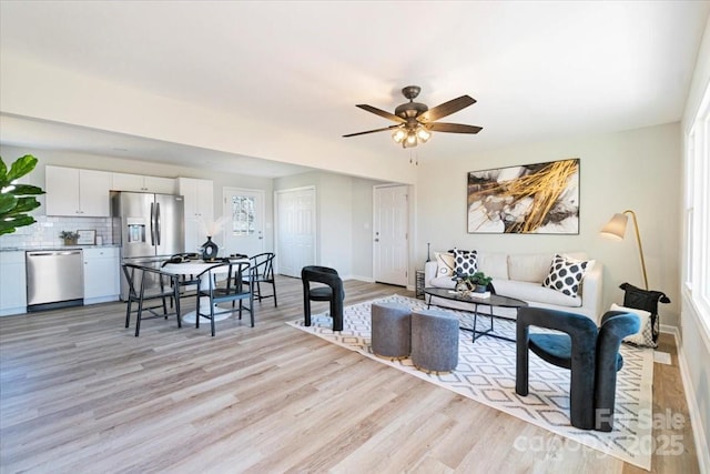 living room with ceiling fan and light wood-type flooring