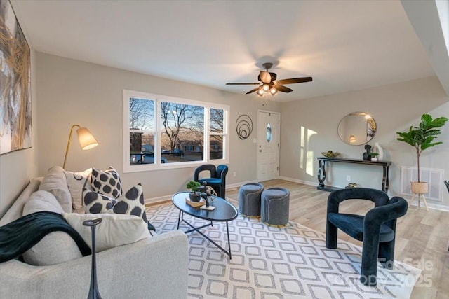 living room featuring ceiling fan and light hardwood / wood-style flooring